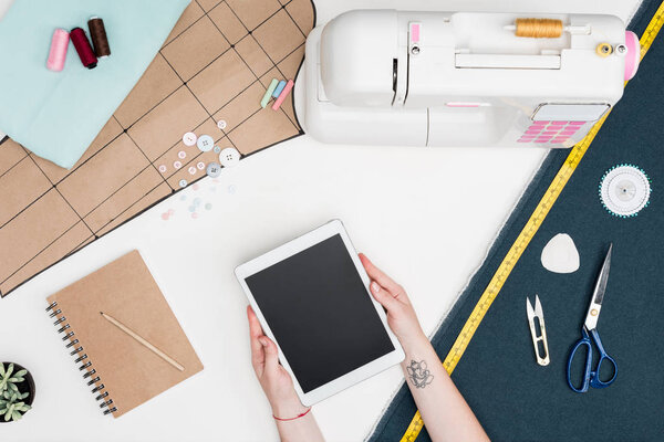 портной с планшетом на рабочем месте
