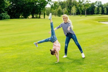 mother with daughter performing handstand clipart