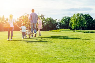 family with dog walking in park  clipart