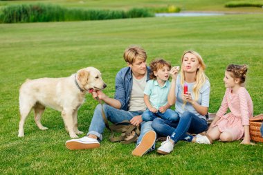 Aile ile köpek çim üzerinde dinlenme 