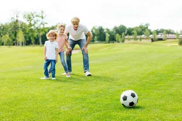 Vader met kinderen te voetballen in het park — Stockfoto