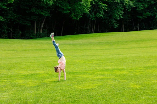 Flicka utför handstående i park — Stockfoto