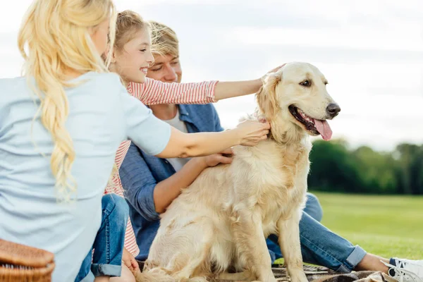 Счастливая семья с собакой в парке — стоковое фото