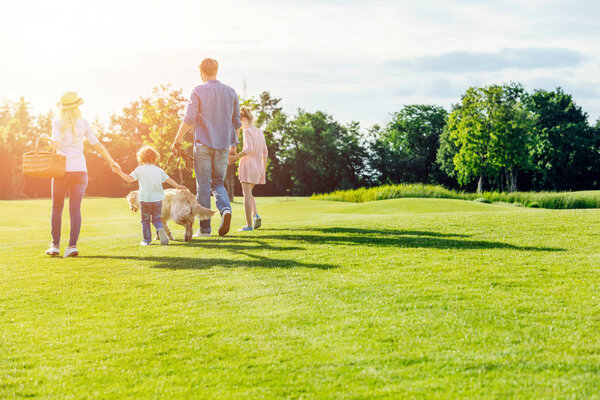 family with dog walking in park 