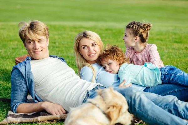 Famille avec chien reposant sur l'herbe — Photo