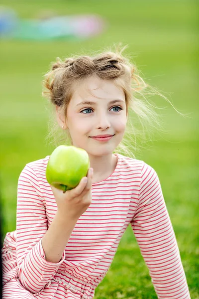 girl eating apple in park