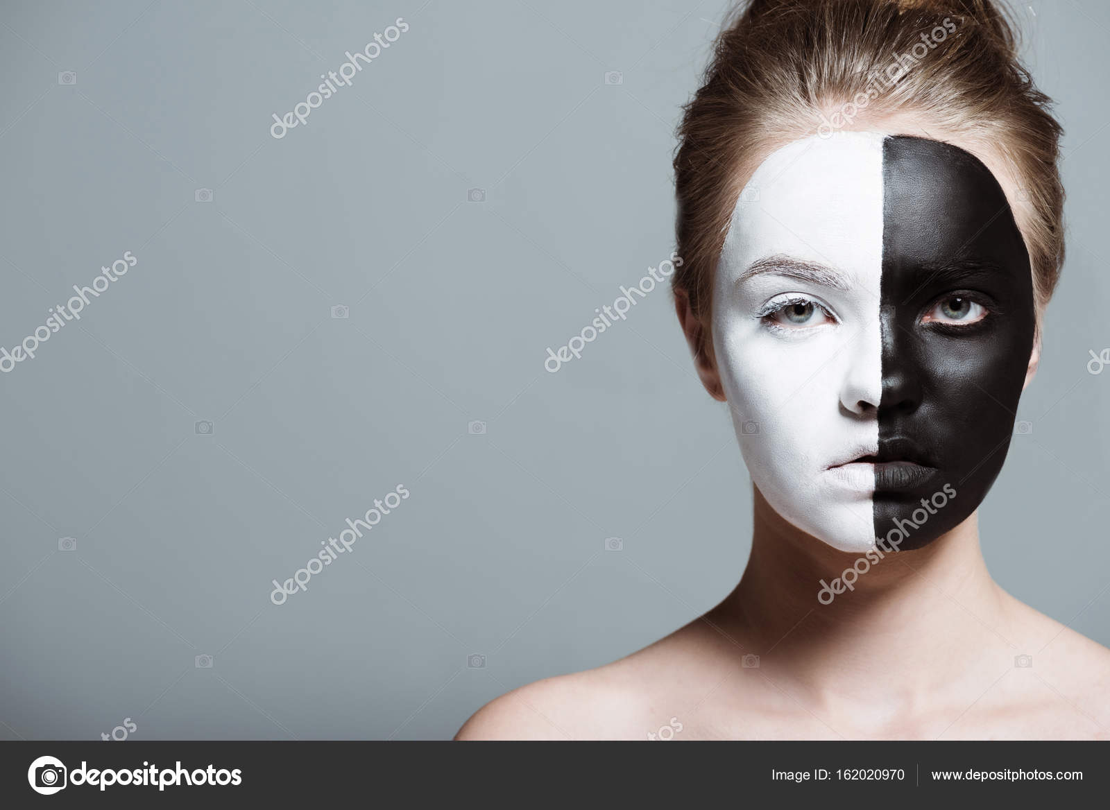 Uma menina com o rosto pintado com tinta preta e branca.