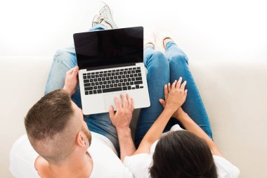 Genç çift dizüstü bilgisayar kullanıyor