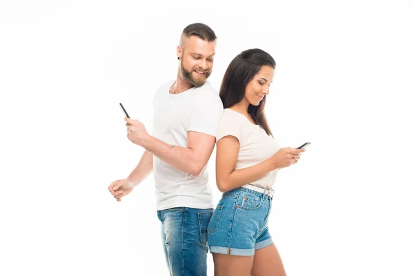 Atractiva pareja usando teléfonos inteligentes — Foto de Stock