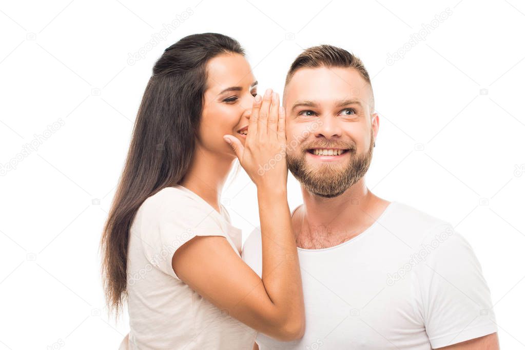 young woman whispering to boyfriends ear
