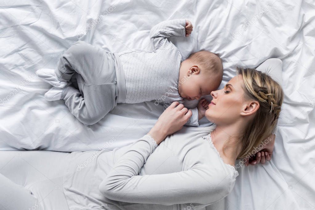 mother with baby sleeping in bed 