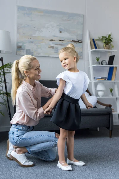 Mother dressing daughter to school — Stock Photo, Image