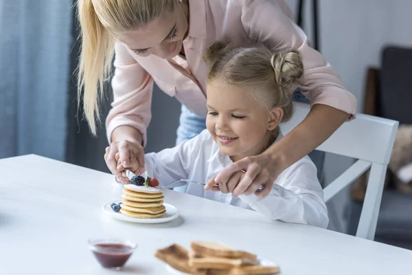 Mor og datter spiser morgenmad - Stock-foto