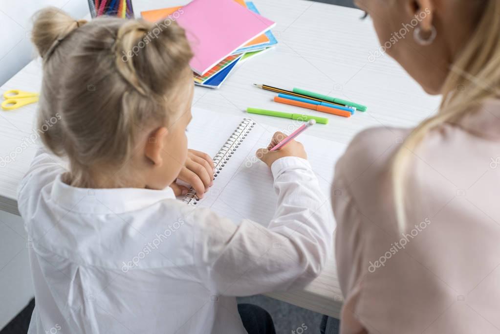 child drawing with mother