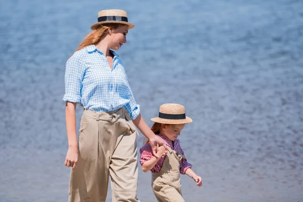 Madre e hija caminando a la orilla del mar —  Fotos de Stock