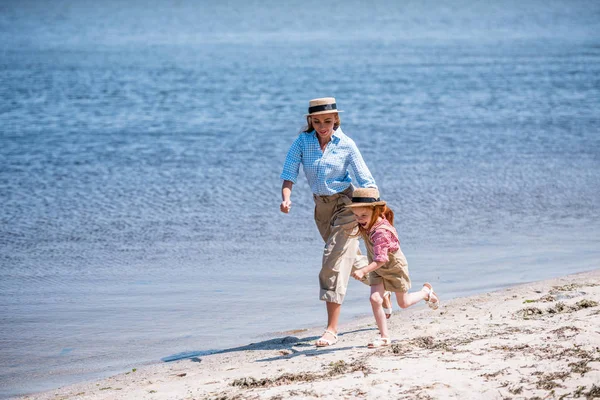 Madre e figlia a piedi in riva al mare — Foto Stock