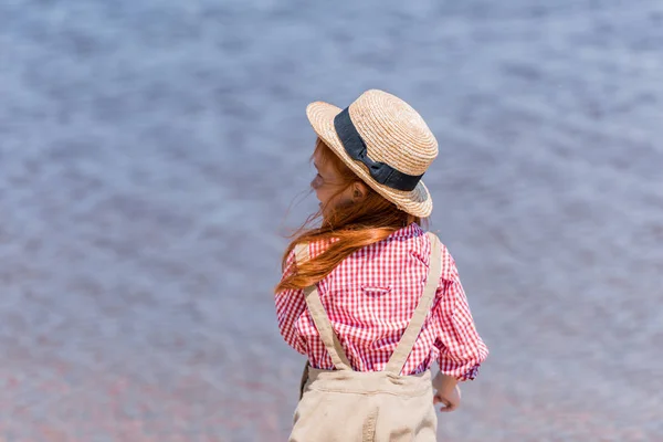 Enfant en chapeau de paille au bord de la mer — Photo