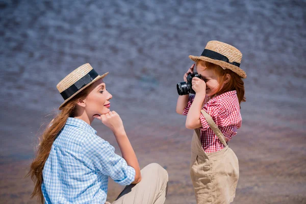 Niño fotografiando madre cerca del mar — Foto de stock gratis