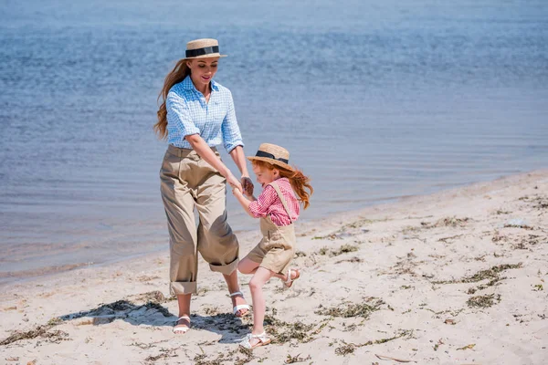 幸福的母亲和女儿在海滩上 — 图库照片