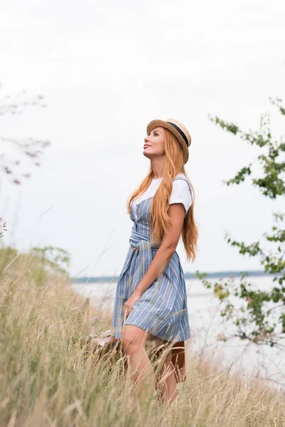 Vrouw met koffer op grasland — Stockfoto