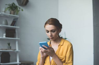 Akıllı telefon kullanan genç bir kadın.