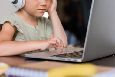laptop ve kulaklık ile küçük kız