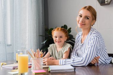 Anne ve kızı ödev yapıyor.