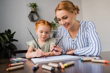 mother and daughter drawing in album clipart