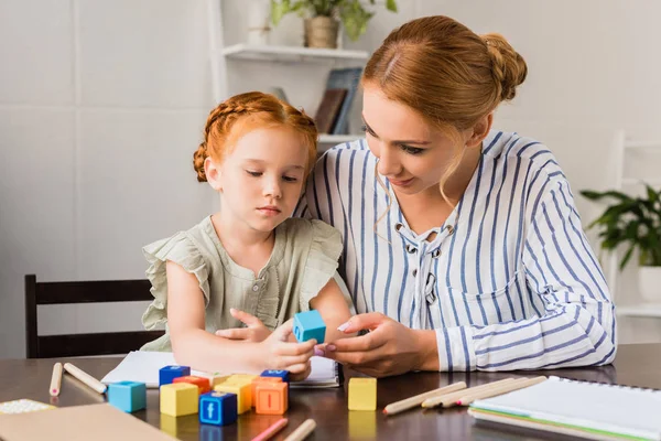 Moeder en dochter leren met brief kubussen — Stockfoto