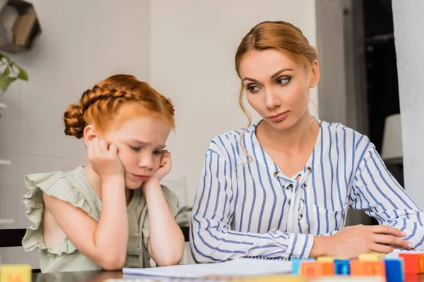Mother looking sceptical on sad daughter — Stock Photo, Image