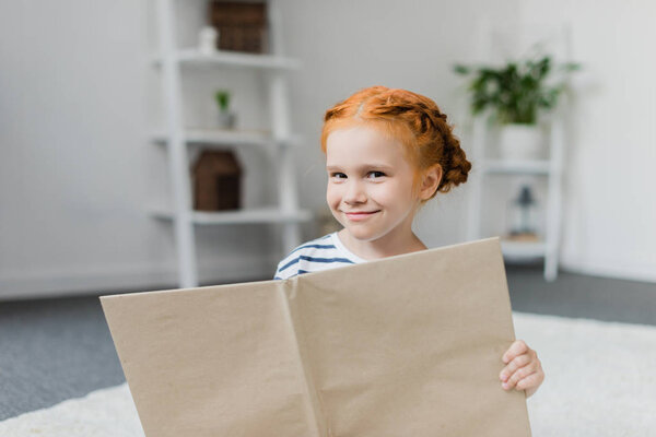 Красивая маленькая девочка с книгой
