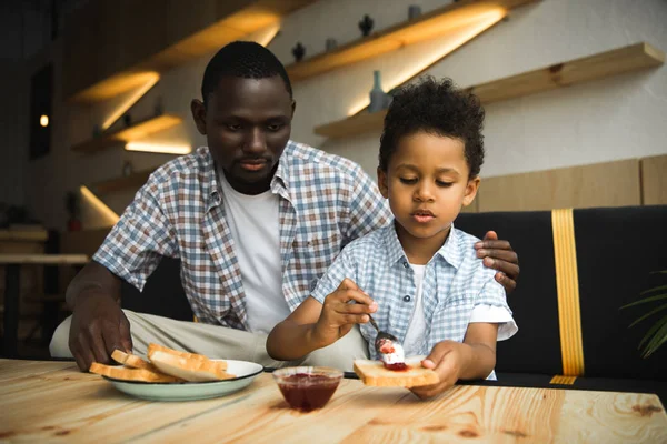 Padre e hijo comiendo tostadas —  Fotos de Stock