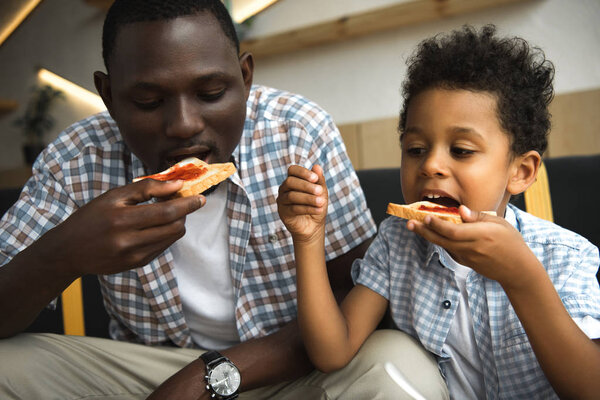 father and son eating toasts