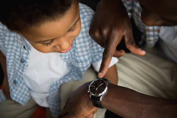 father and son checking wristwatch