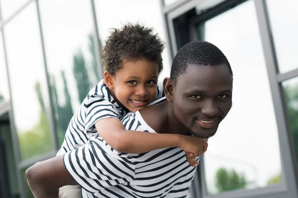 Afro-americano pai piggybacking filho — Fotografia de Stock