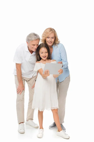 Girl with grandparents looking at tablet — Free Stock Photo