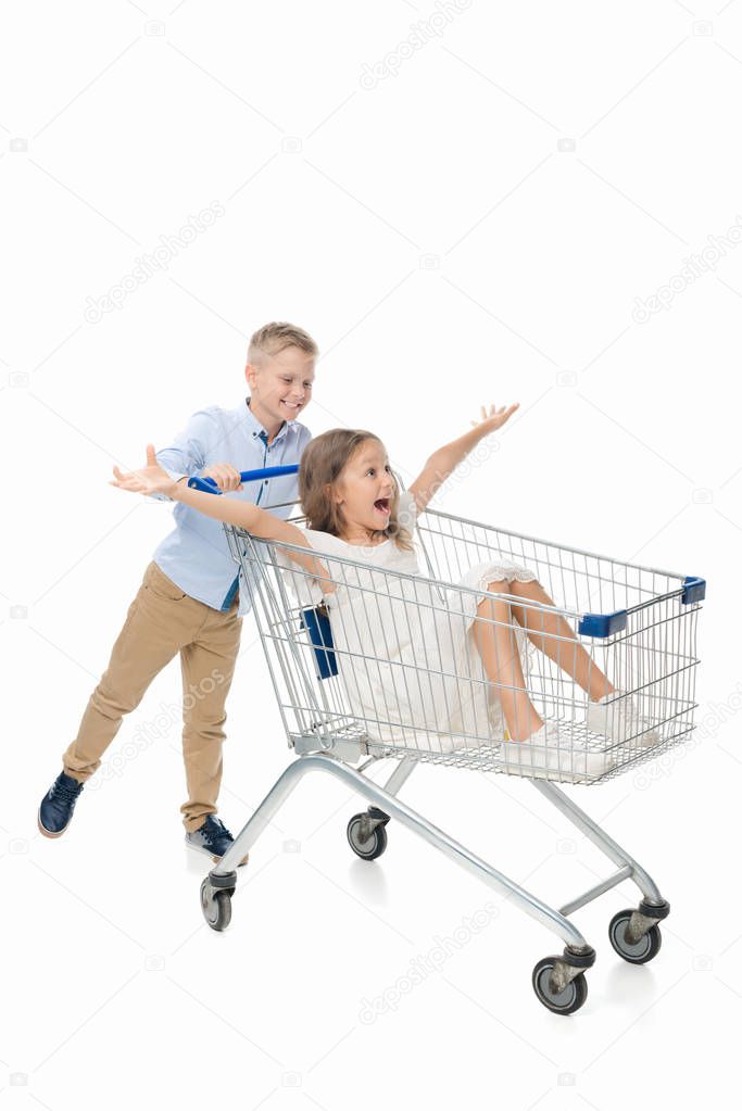 brother riding sister in shopping cart