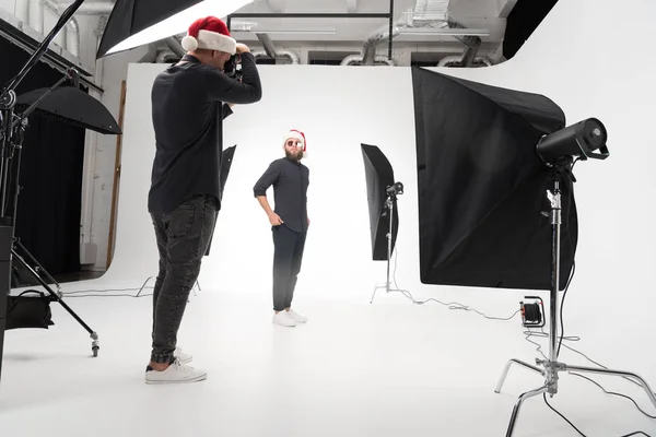 Photographer working in studio with model — Free Stock Photo