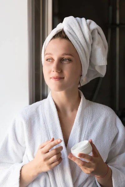 Mujer aplicando crema facial — Foto de Stock