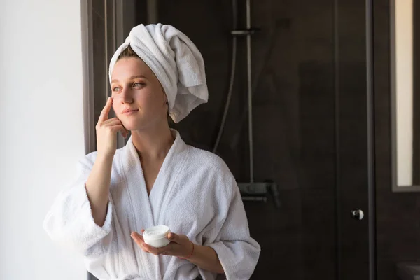 Mulher aplicando creme facial — Fotografia de Stock