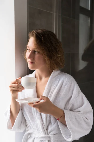 Girl in bathrobe drinking coffee — Stock Photo, Image