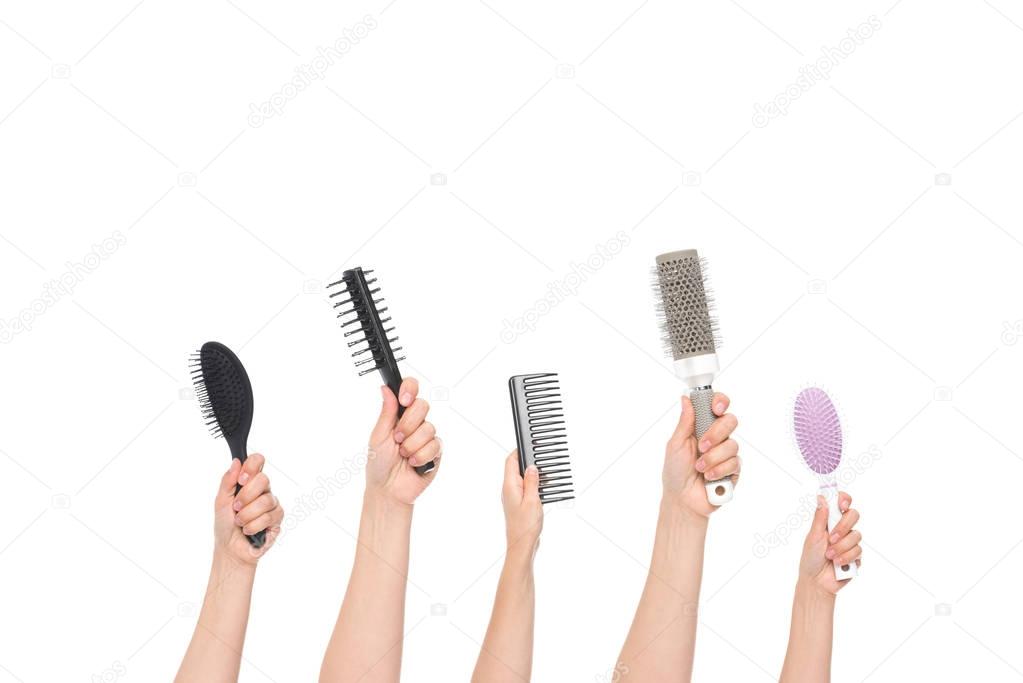 hands holding hairbrushes