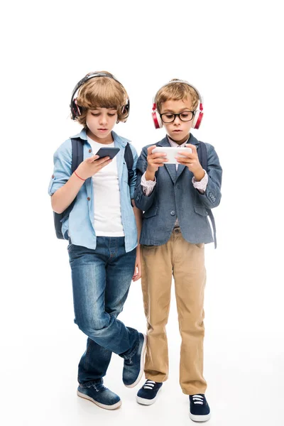 Fokuserad skolpojkar använder smartphones — Stockfoto
