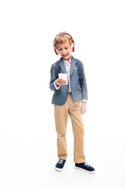 Schoolboy using headphones and smartphone — Stock Photo, Image