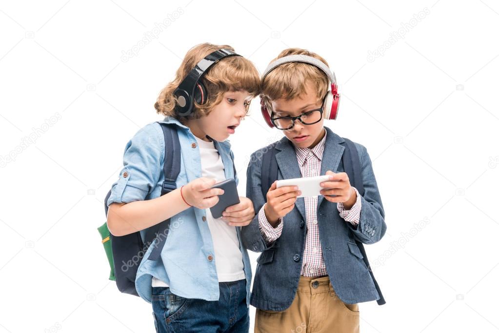 excited schoolboys using smartphones 