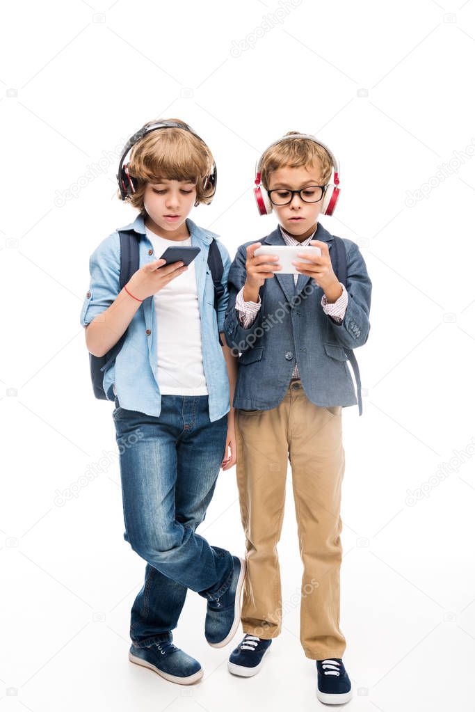 focused schoolboys using smartphones 