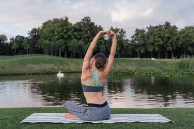 woman stretching on yoga mat clipart