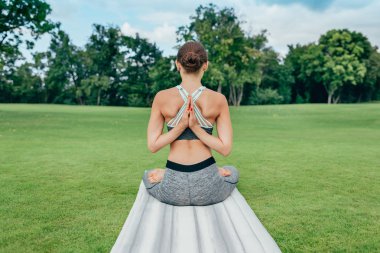 Yeşil çimenlerin üzerinde meditasyon kadın