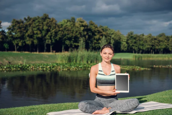 Frau praktiziert Yoga mit Tablet — Stockfoto
