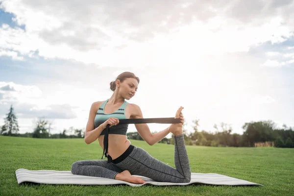 Kobieta siedzi w pozycji jogi — Zdjęcie stockowe